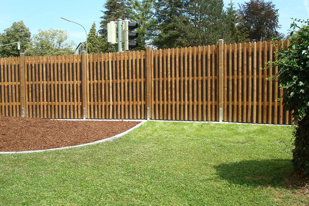 Garten mit einem Schallschutzzaun, gebaut aus soni RESIST UV mit Holzleisten verkleidet