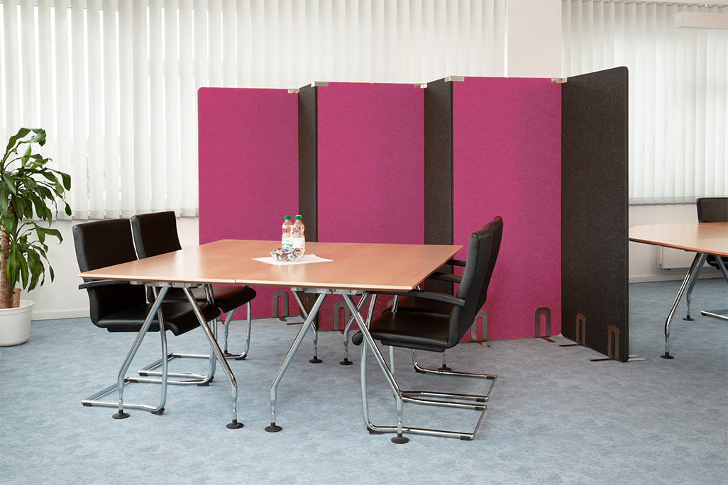 Meeting room with a table and 4 chairs, behind it 5 soniflex partitions next to each other as a separate wall in the room