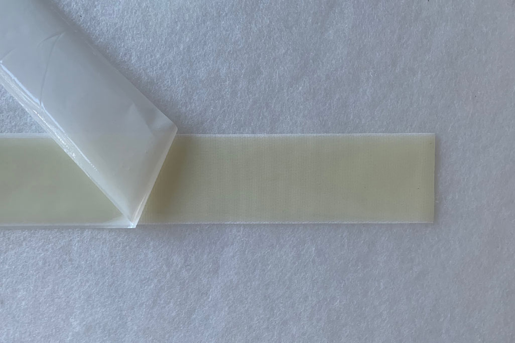 Sample of a white PES-VLieses, to which a soni KLettband was attached